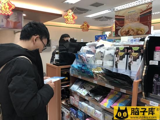 今日上午，北京南站便利店内，一位男士正在挑选口罩。新京报记者 张静姝 摄